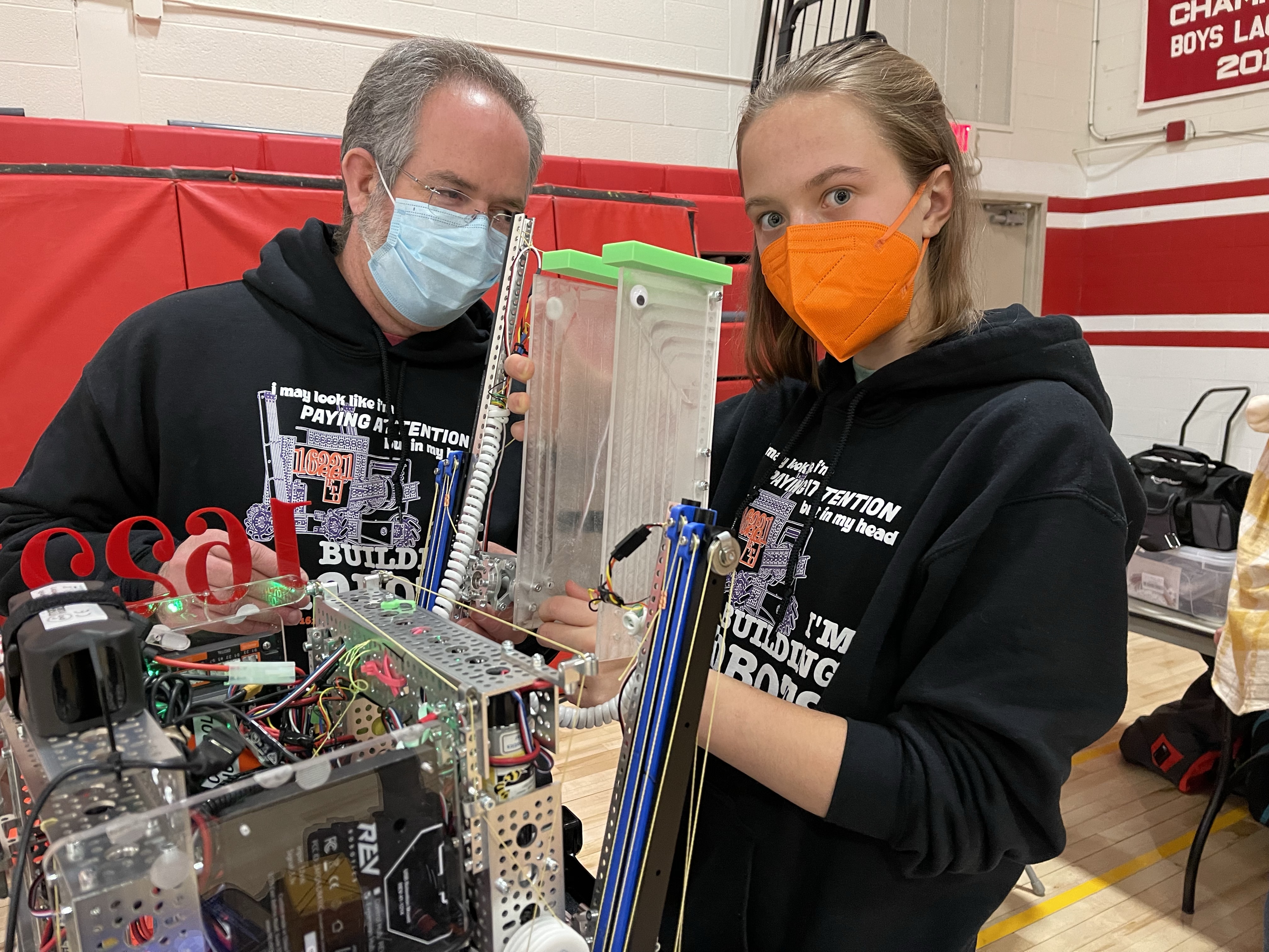Charlotte and Coach David inspect Freya, the robot.