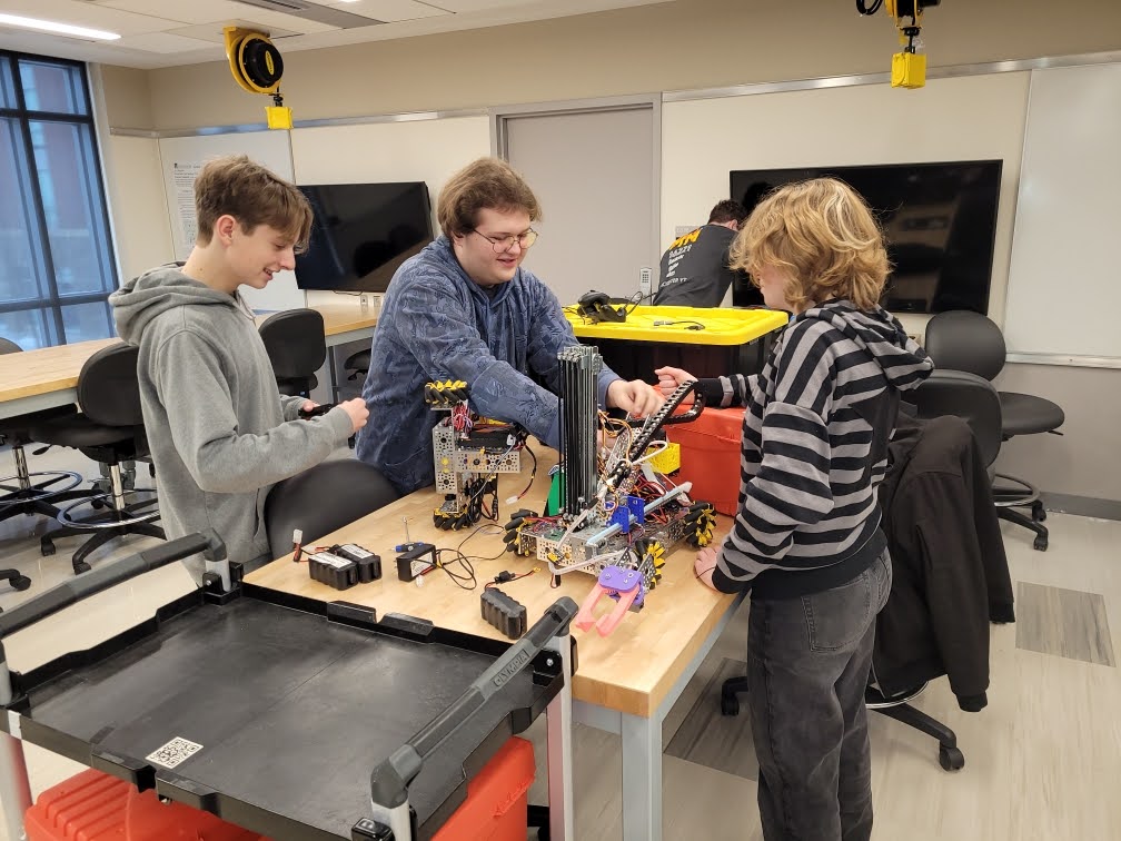 Team members make last-minute adjustments to robots Cordelia and Fred.